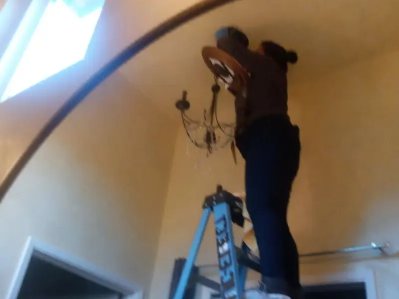 Electrician installing a chandelier in a Combined Locks residence